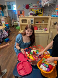 Teacher playing with students using plastic groceries