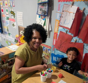 A teacher and student playing with playdoh and markers
